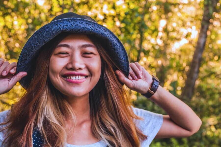 woman wearing hat smiling into camera how to transition from staff nurse to travel nurse