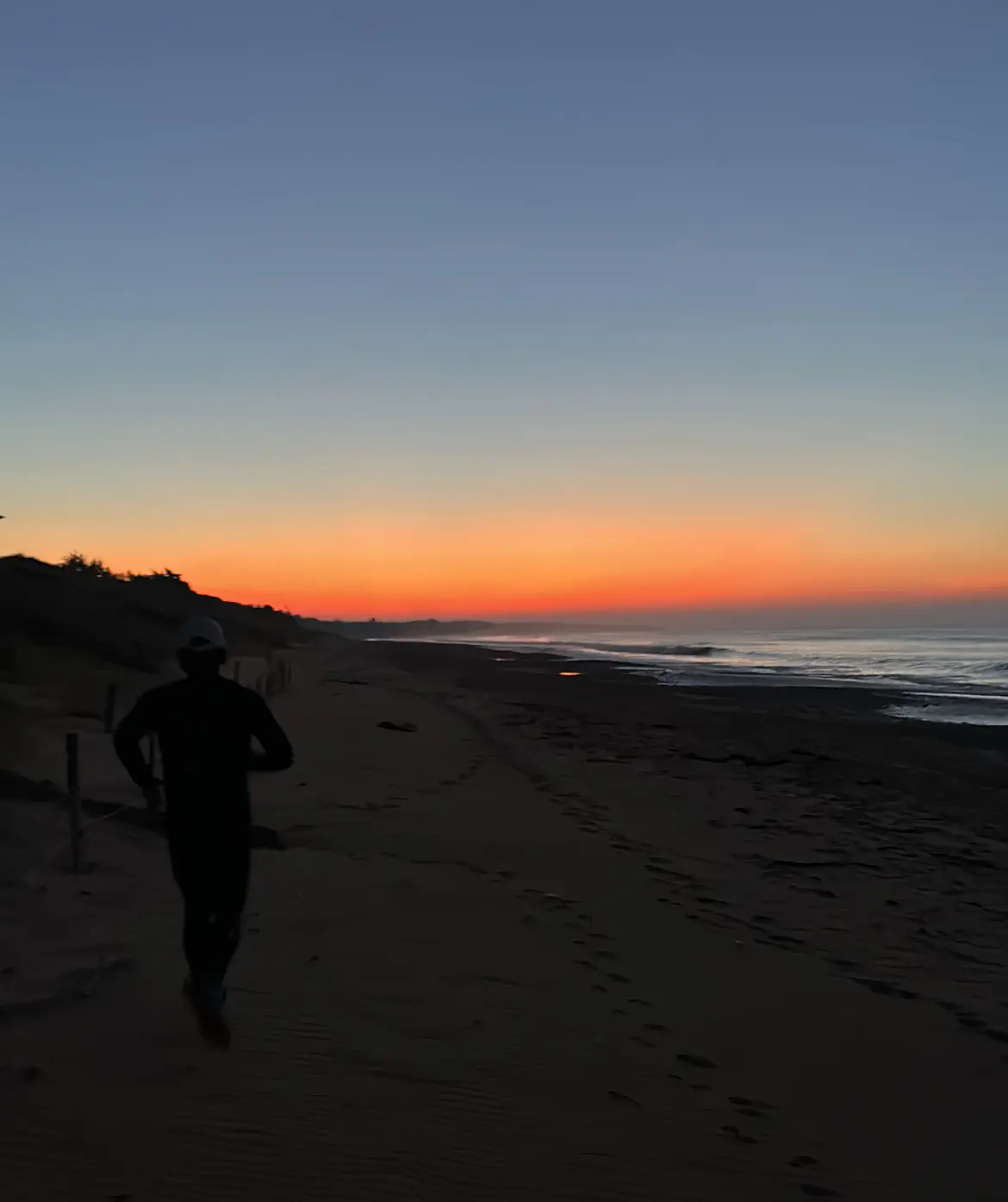 Thomas courant sur la plage au levé du soleil