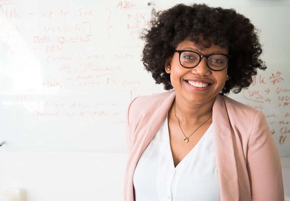 woman smiling in front of whiteboard