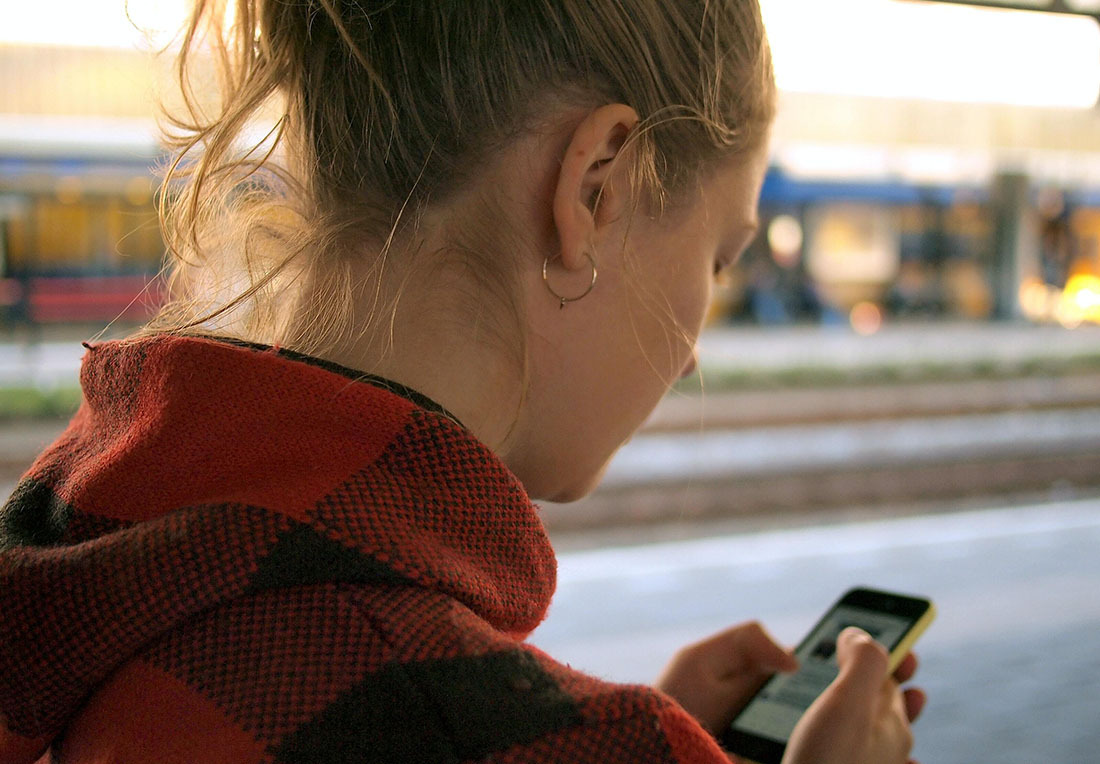 a woman looks at a phone