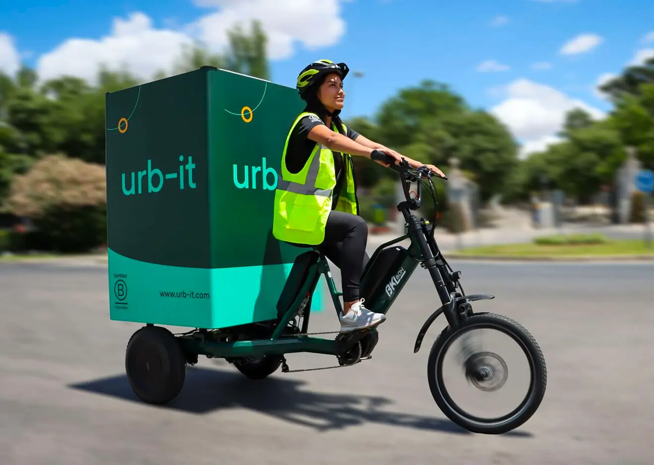 An Urb-it courier riding an Urb-it tricycle on the road