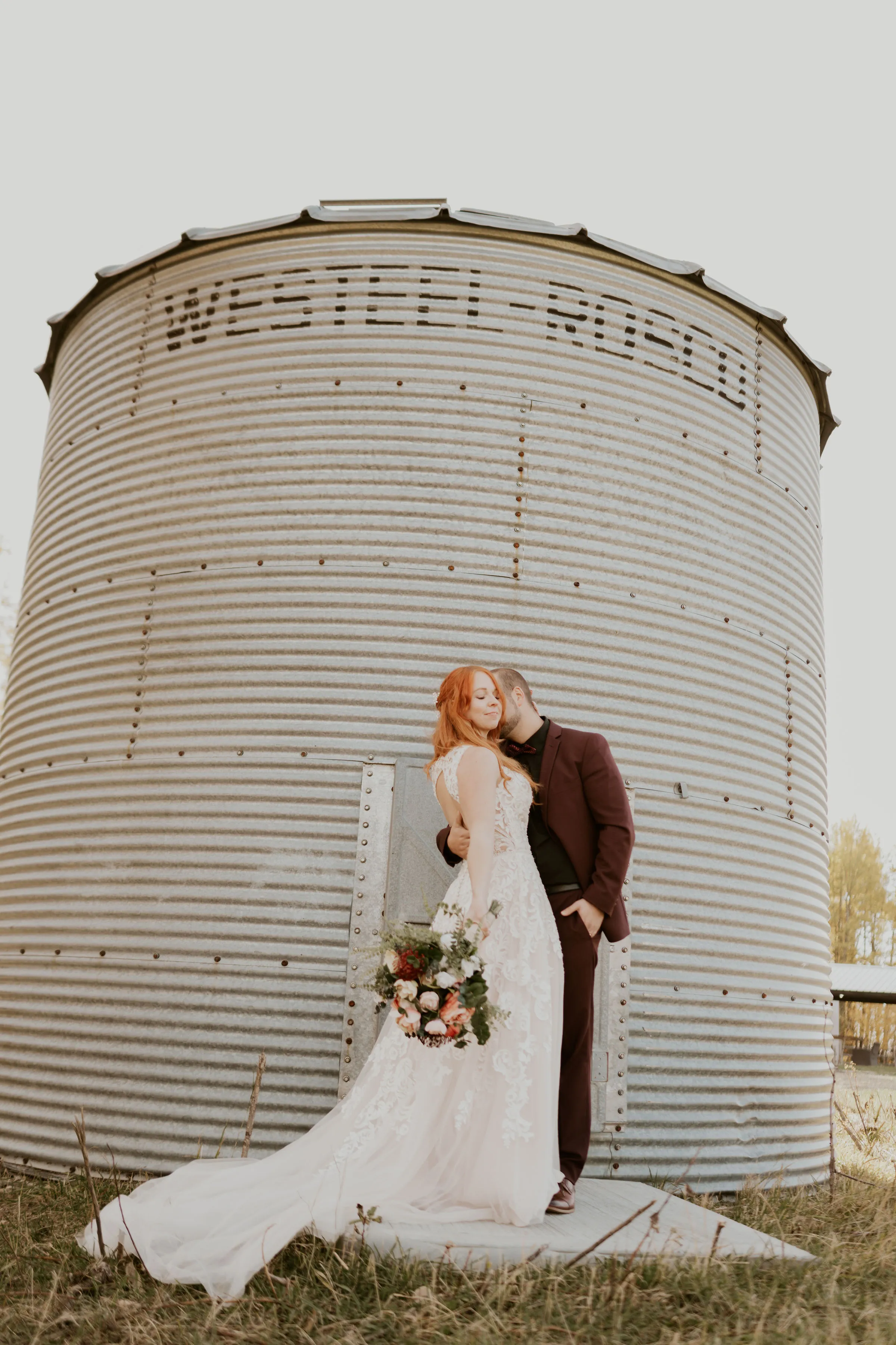 Bride and Groom standing in front of grain silo