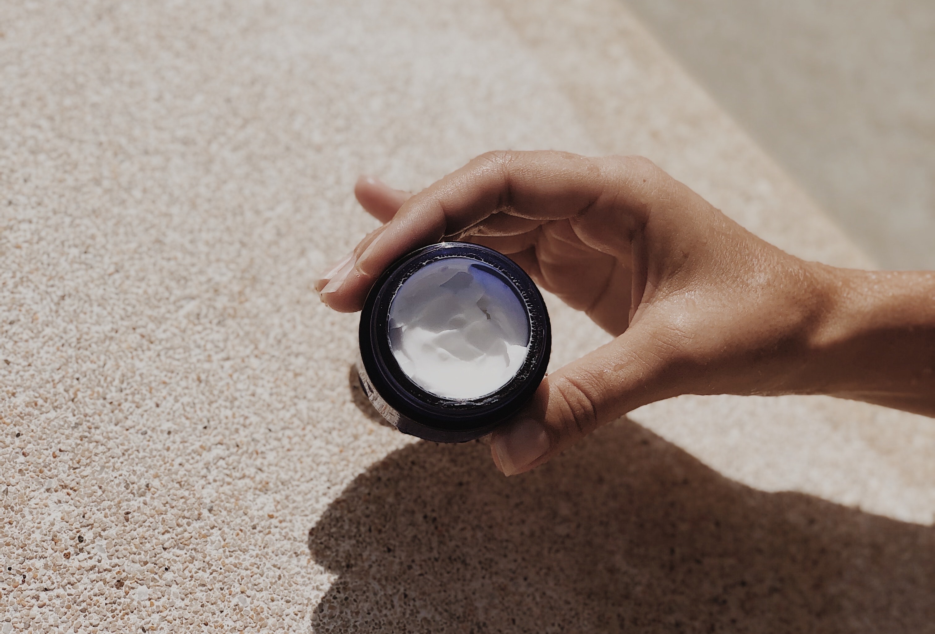 image of a small cosmetics container with cream textured skincare