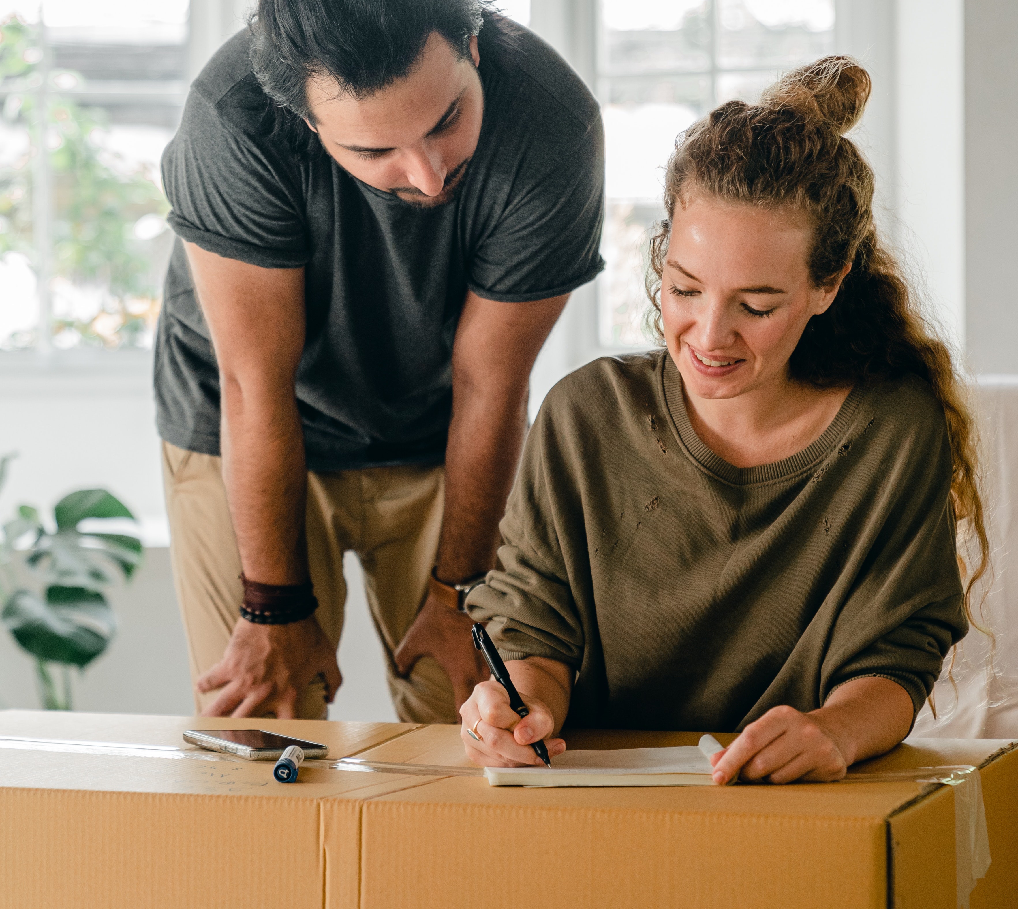 A couple filling out a customs declaration on their box