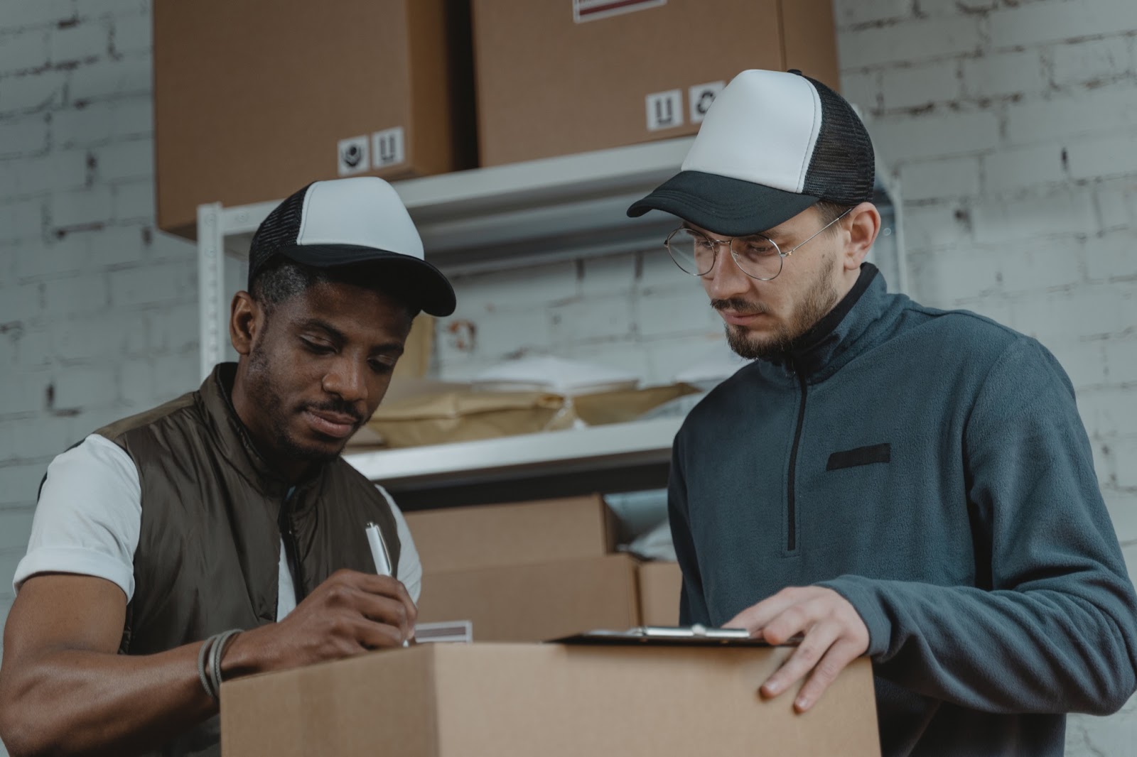 Two men working together to fill out customs declaration forms