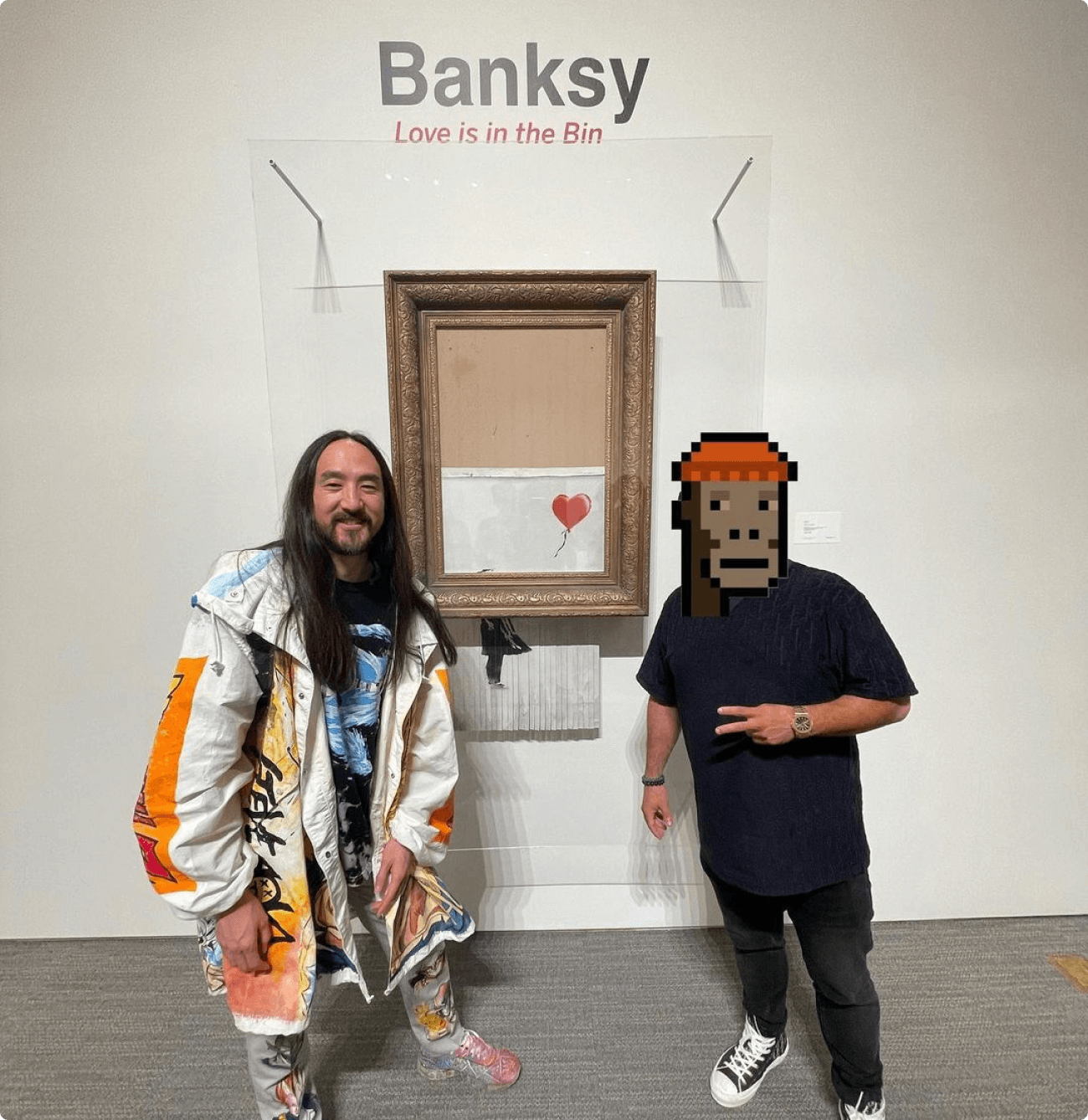 Gmoney and Steve Aoki with a Banksy piece in an art exhibition