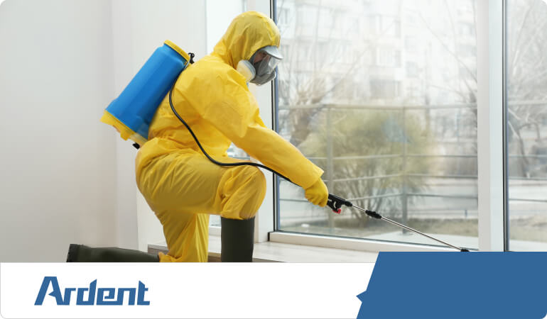 Commercial service technician spraying house with pest control services.
