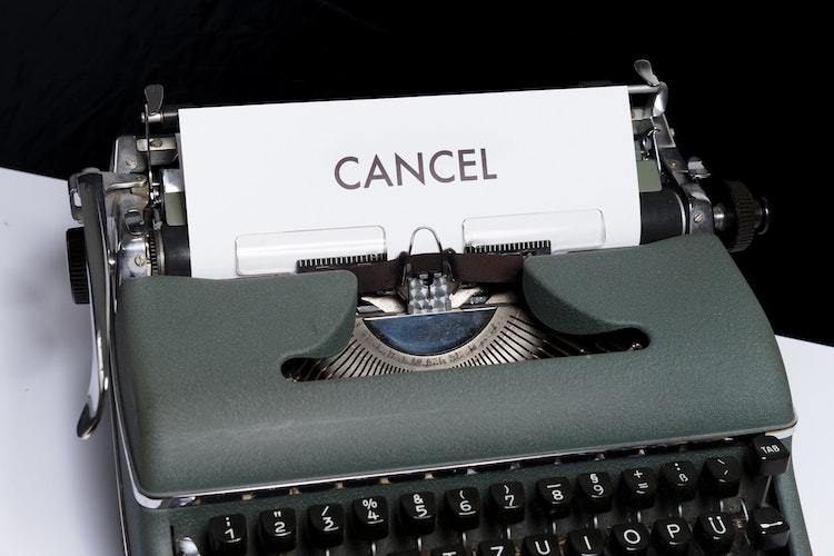 typewriter with the word cancel written typed on paper