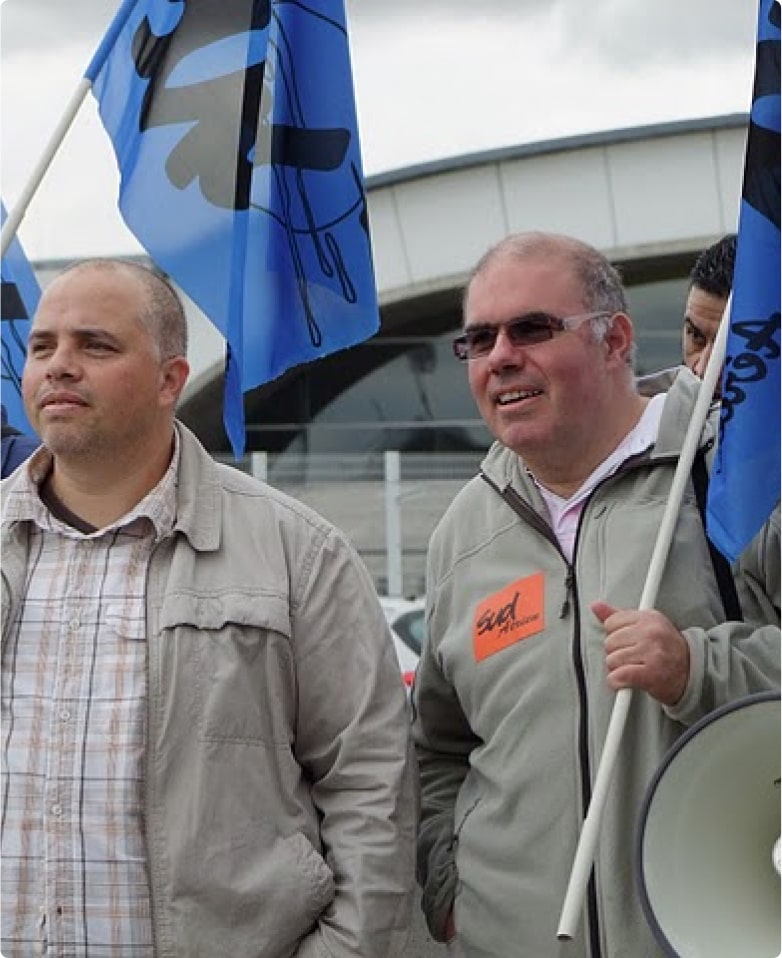 Deux hommes portent un drapeau Sud Aérien