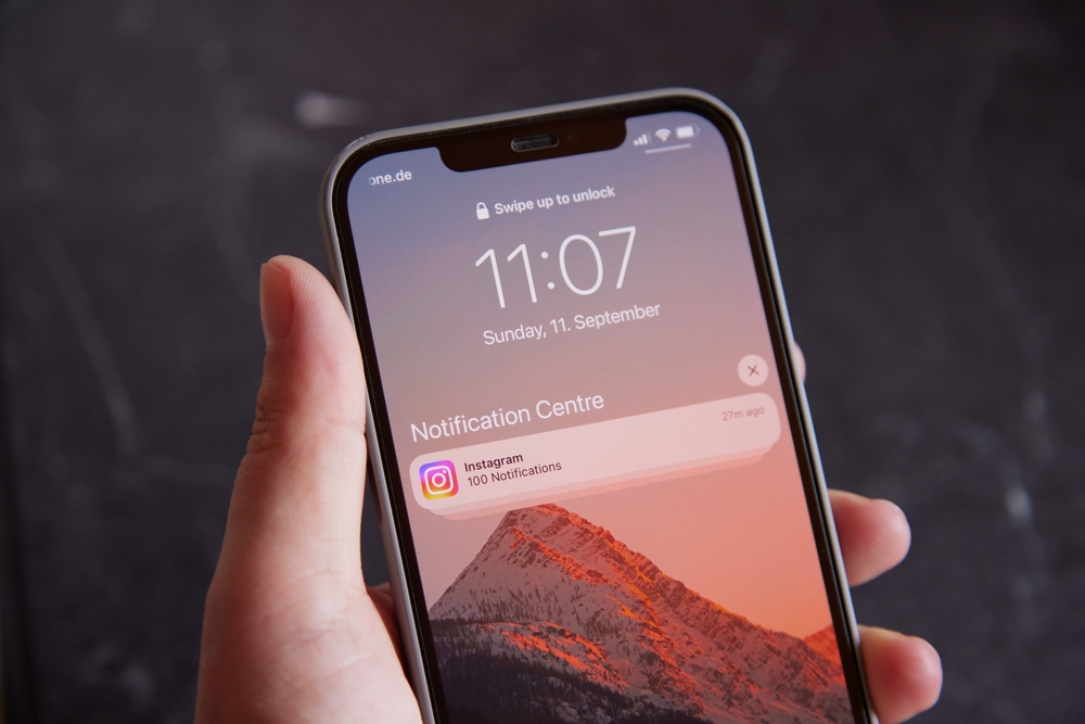 Close up of phone home screen showing 100 notifications from Instagram.