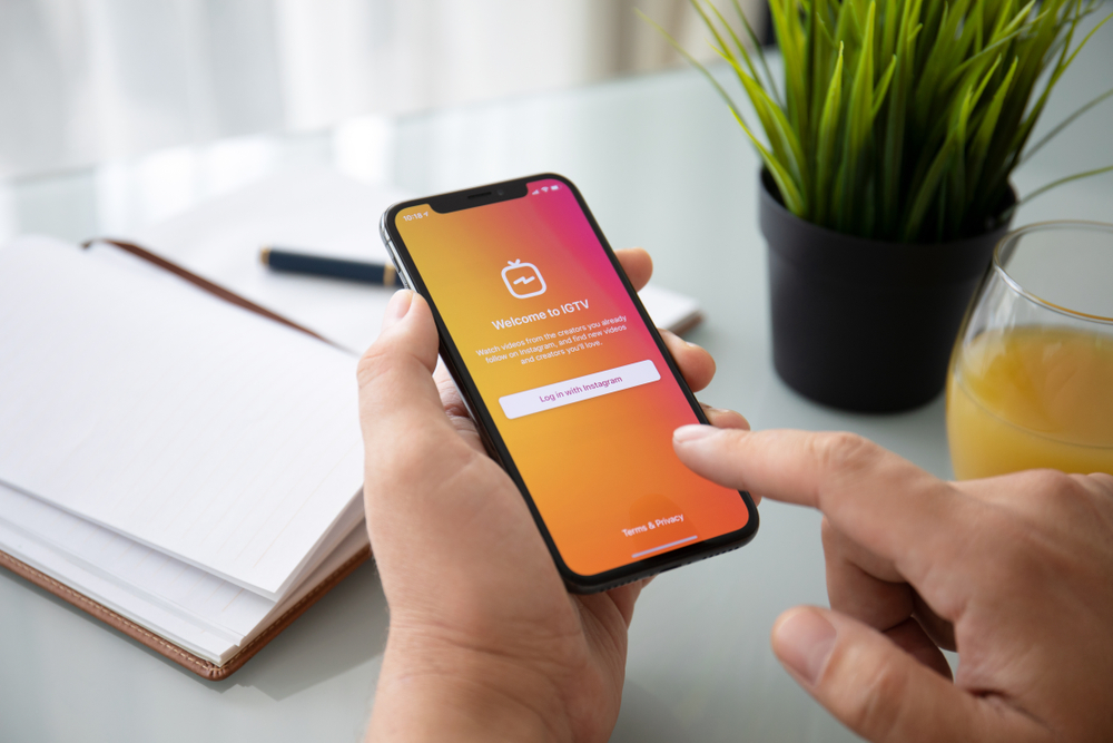 Hands holding a phone logining in to IGTV.