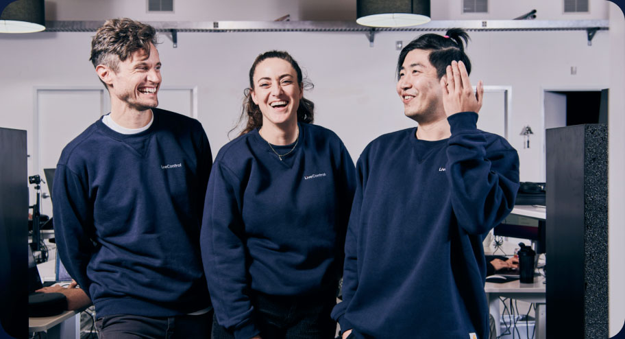 A group of three laughing LiveControl employees.