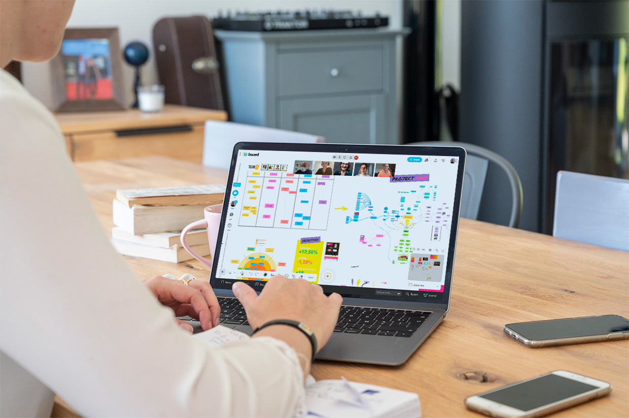 A person working on desktop, with their team connected remotely on a Board where they are sharing many ideas. | Klaxoon