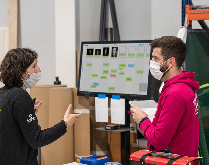 Deux personnes devant un MeetingBoard échangent