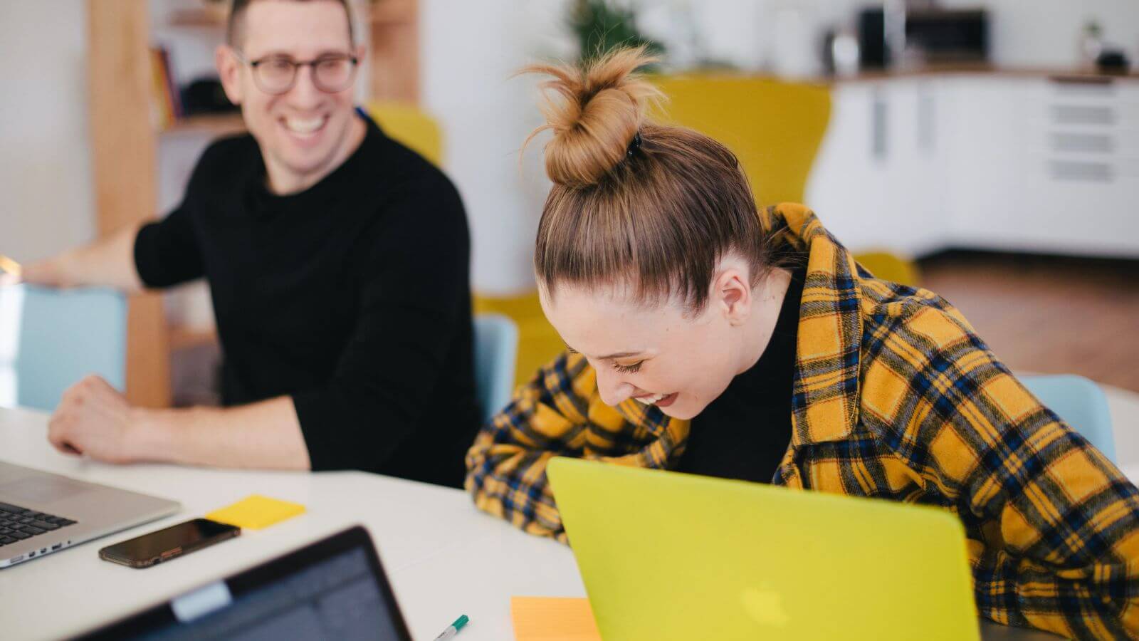 Woman laughing while working with colleague