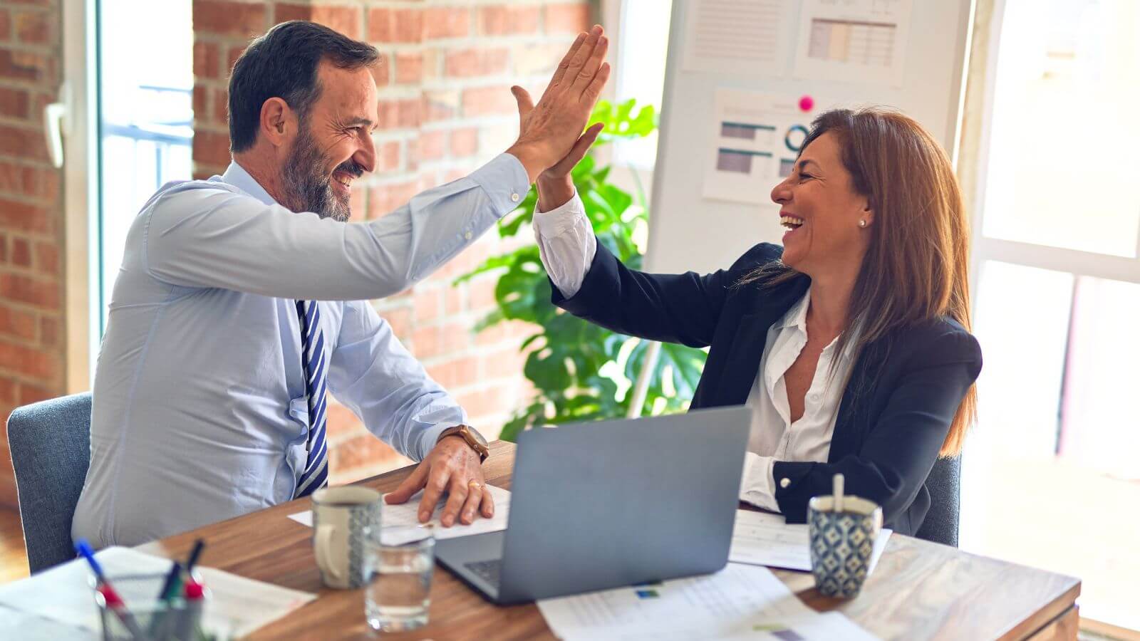 Coworkers high-fiving during meeting
