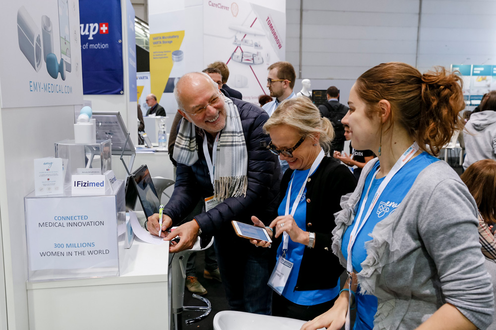 A man and 2 women smiling while registering for the event