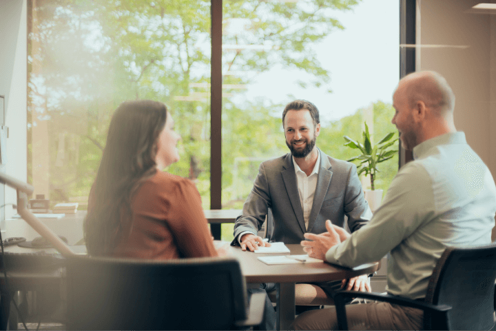 Christensen Group Insurance agent meeting with two clients in an office
