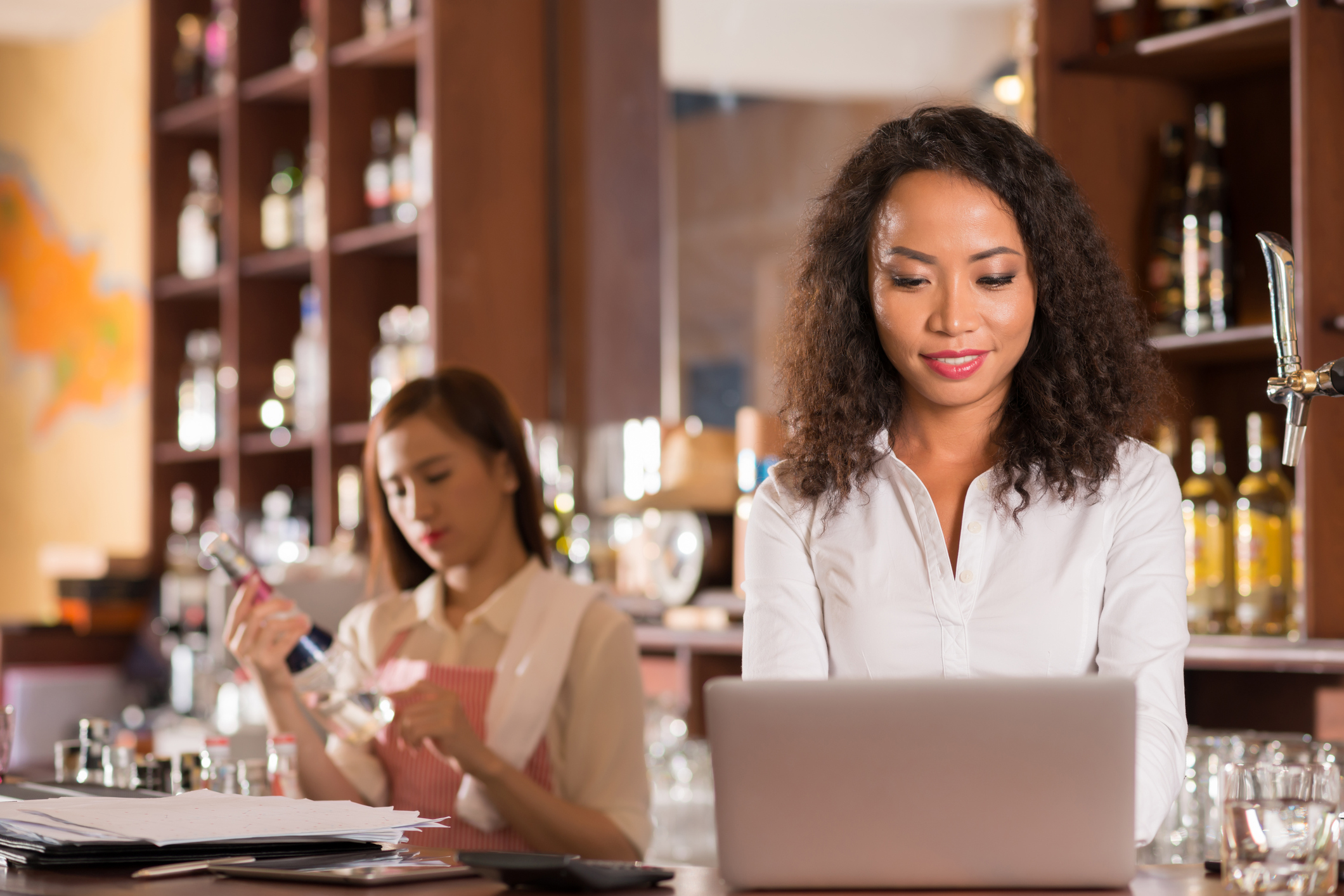 Woman on laptop in wine bar