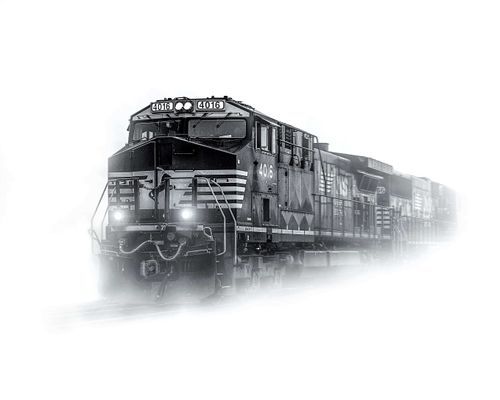 A black and white train traveling in the fog.