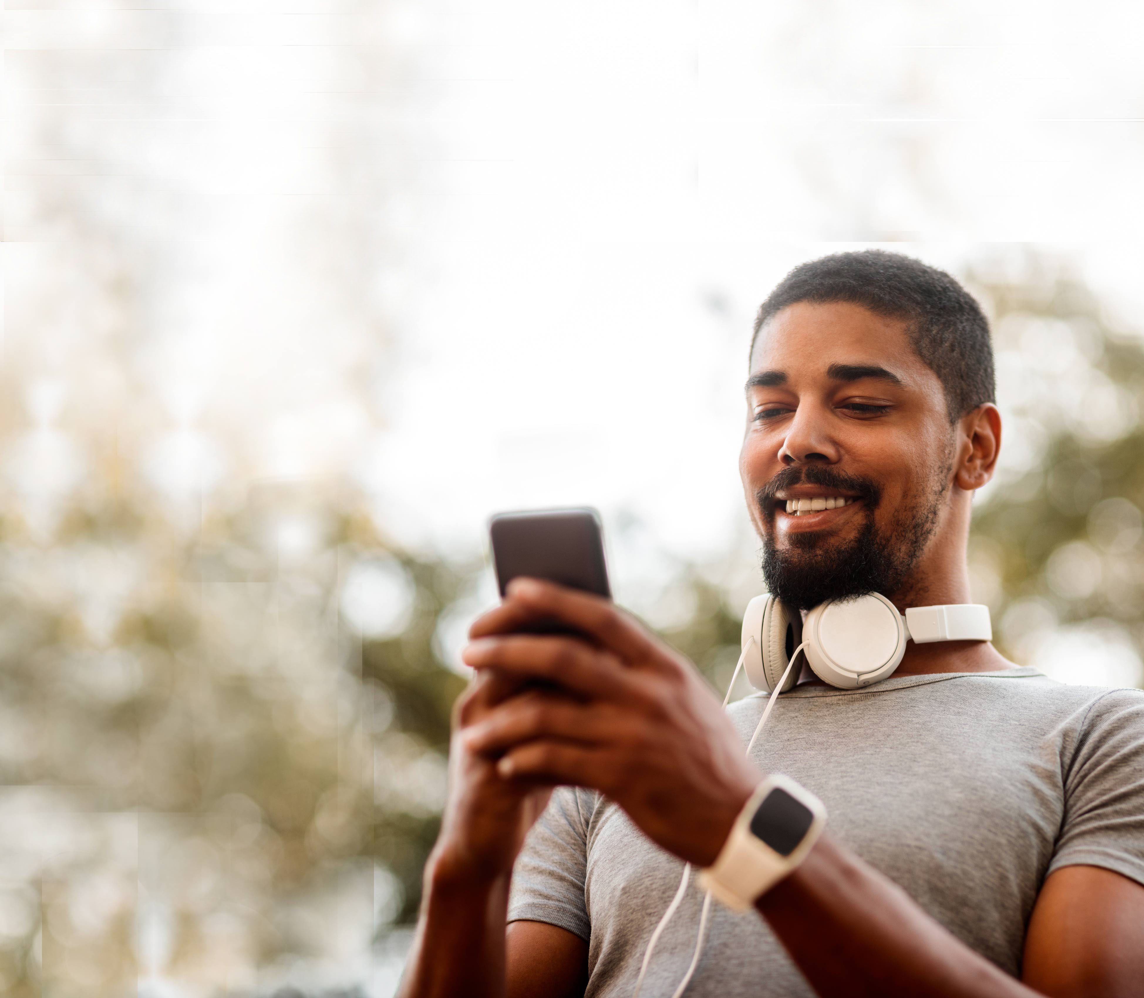 30-something black man smiling and looking at his phone
