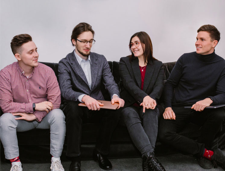 four persons chatting while sitting on a couch