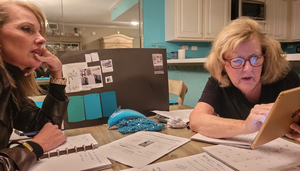 2 Older Women Sitting At Dining Room Table Thinking Whether Or Not If They Should Opt For Actual Cash Value In Their Insurance Policy