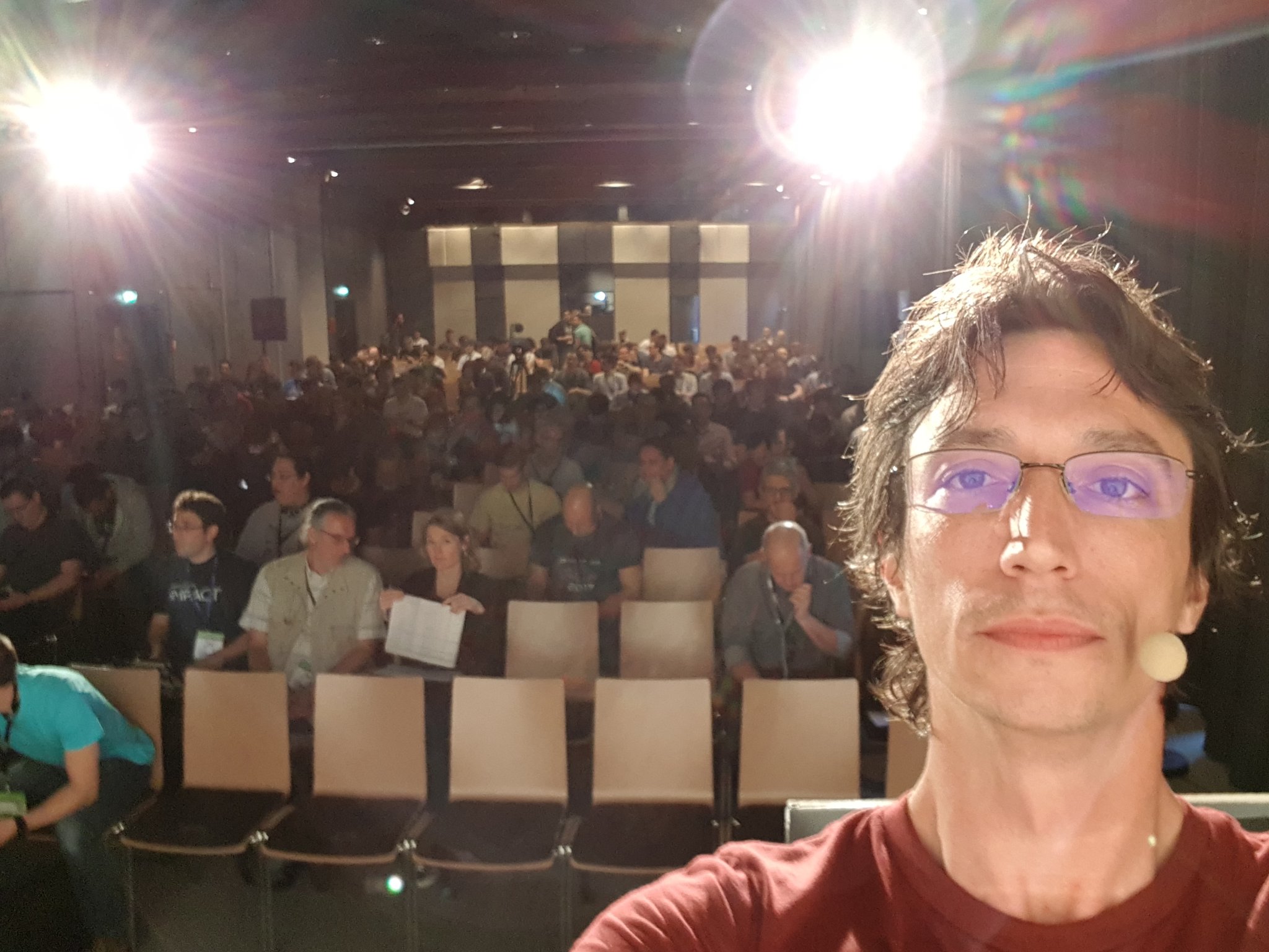 Picture of Jonathan Roquelaure, Solution Architect at Blink, taking a selfie in front of a conference crowd where he is the presentor.