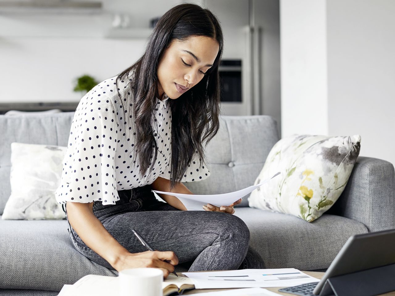 Girl calculating expenses with calculator and laptop
