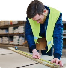 Tradesman measuring and cutting wood