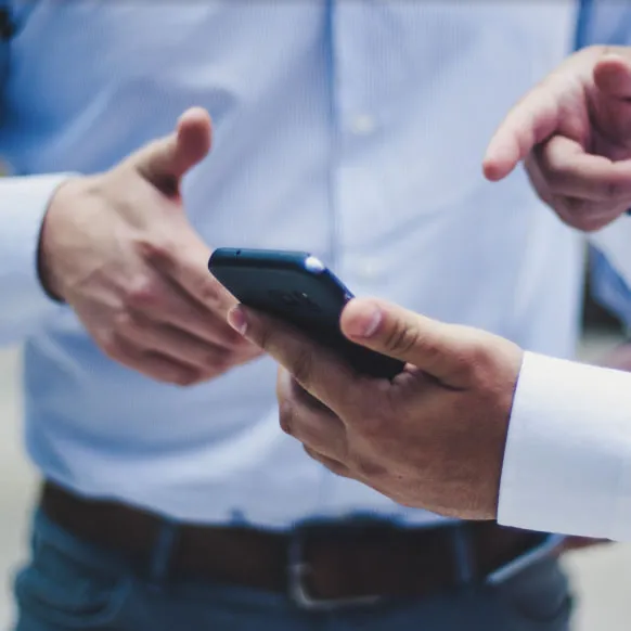 a few hands holding a smart phone