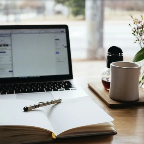 a laptop and a pen on a table