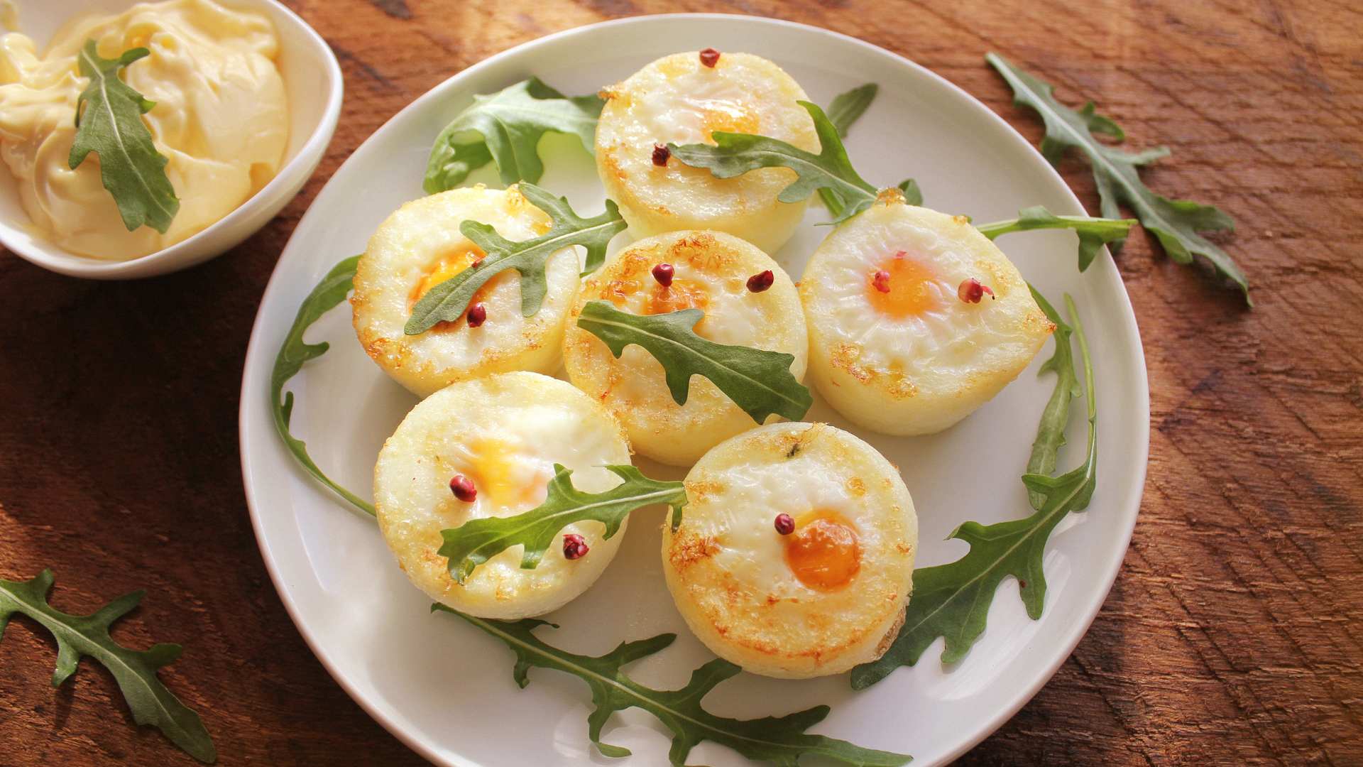 Pochierte Eier mit Rucola auf einem Teller.