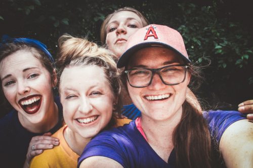 Four friends take a selfie outside.