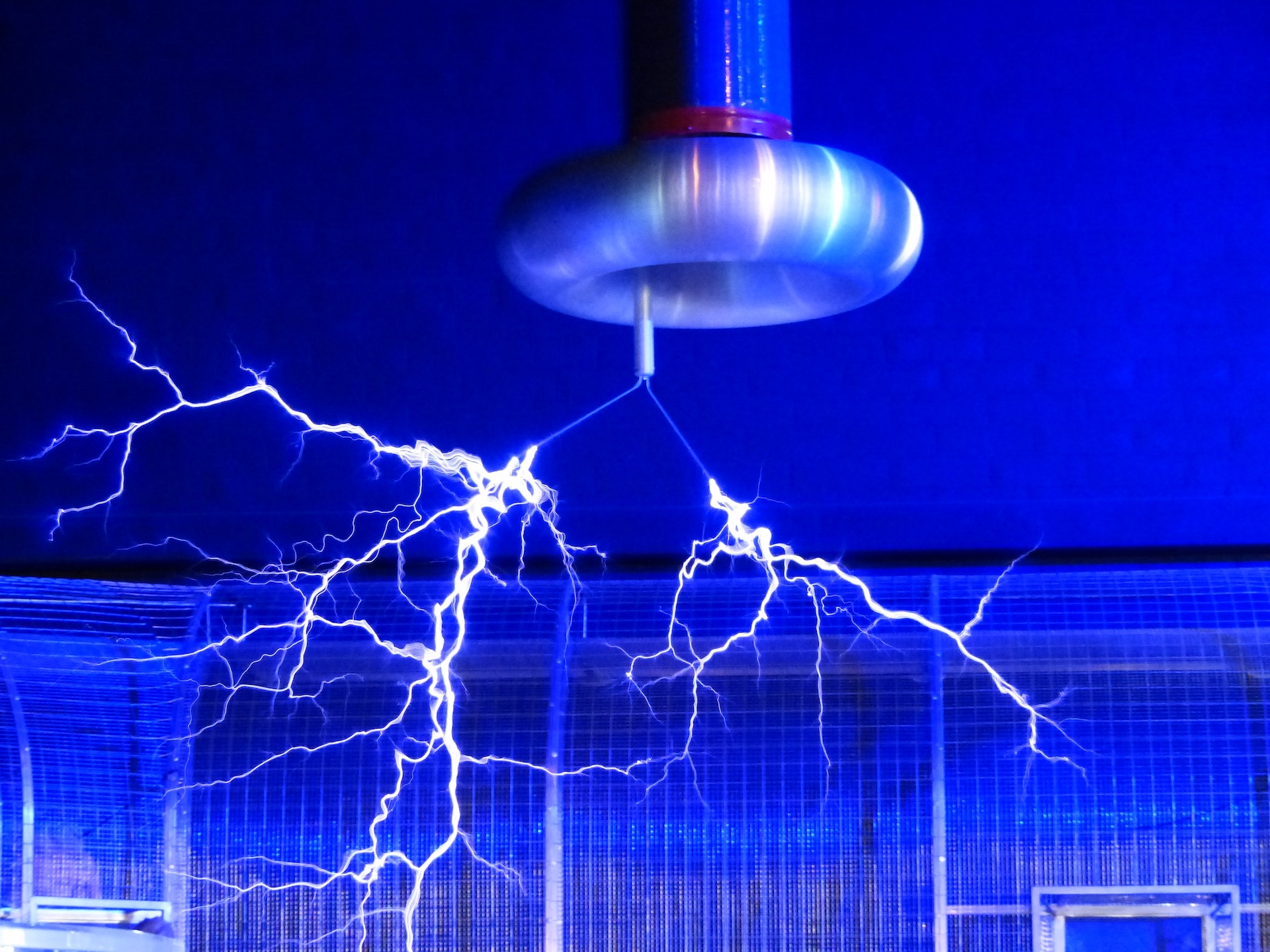 Electricity shoots out of a metal cylinder in the ceiling.