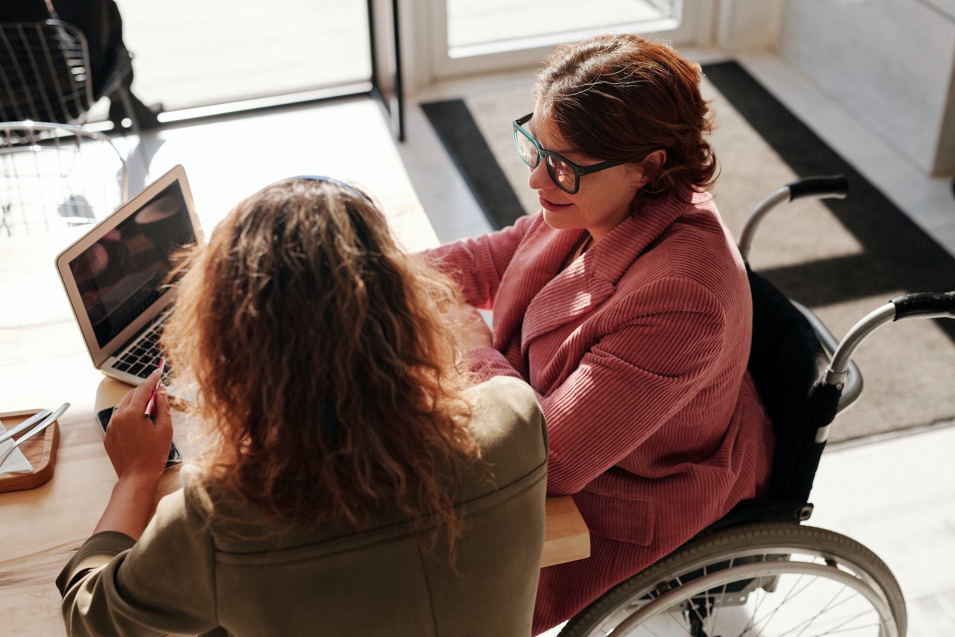Two writers sit at a table reviewing a query letter.