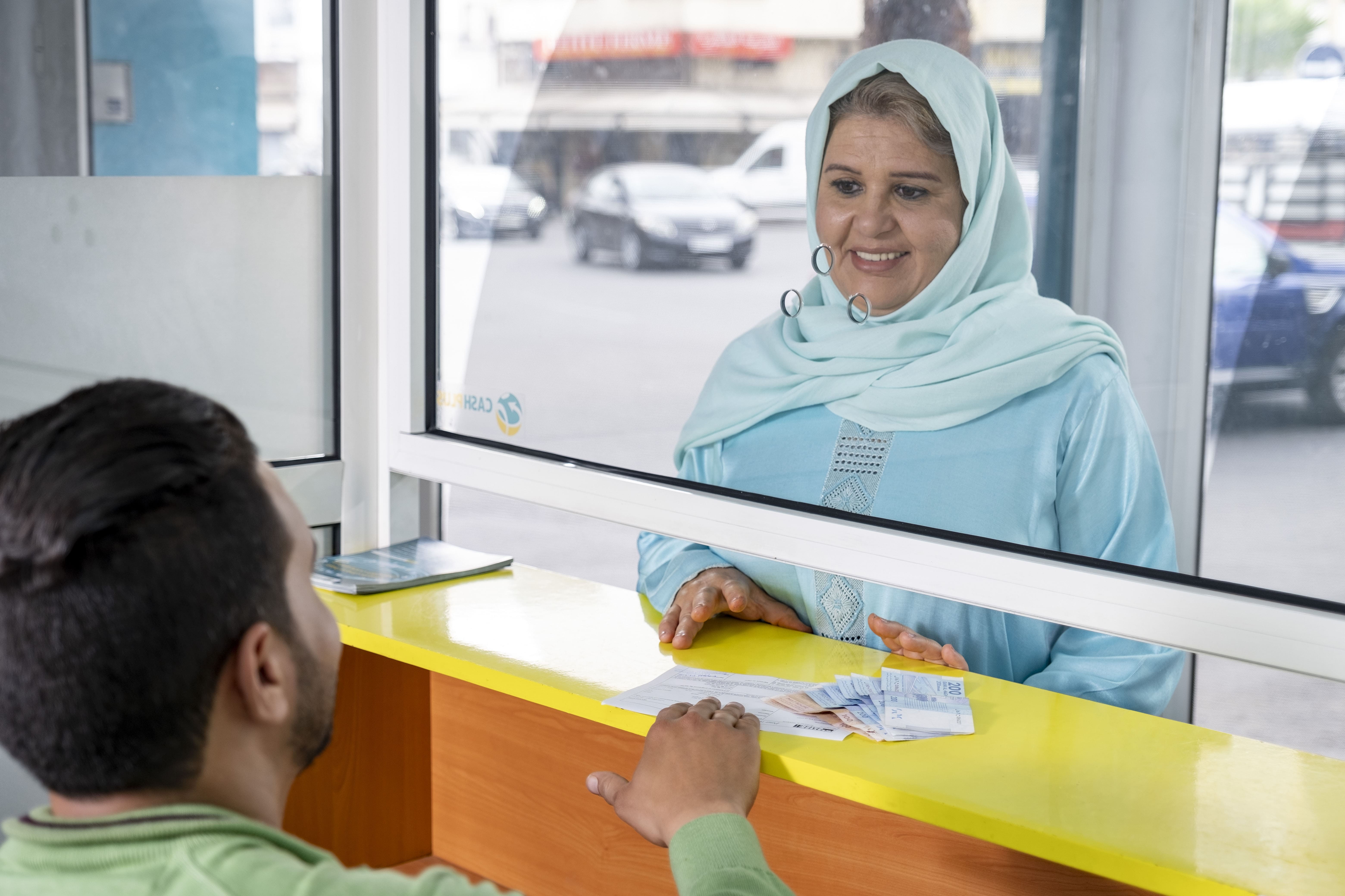 Une femme qui se rend dans une agence Cash Plus pour récupérer de l'argent qui a été envoyé depuis l'étranger