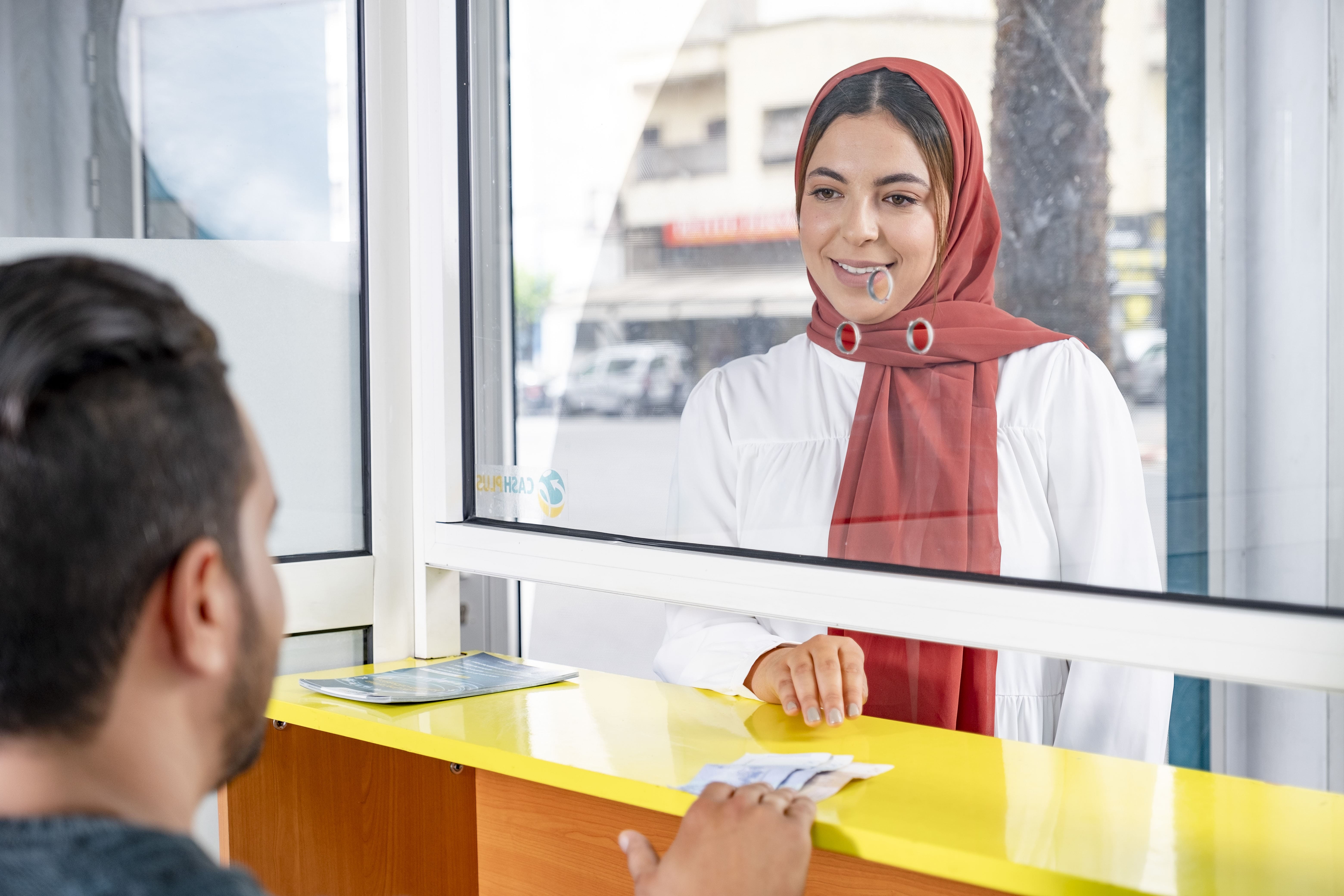 Une femme qui se rend dans une agence Cash Plus pour effectuer un transfert d'argent national