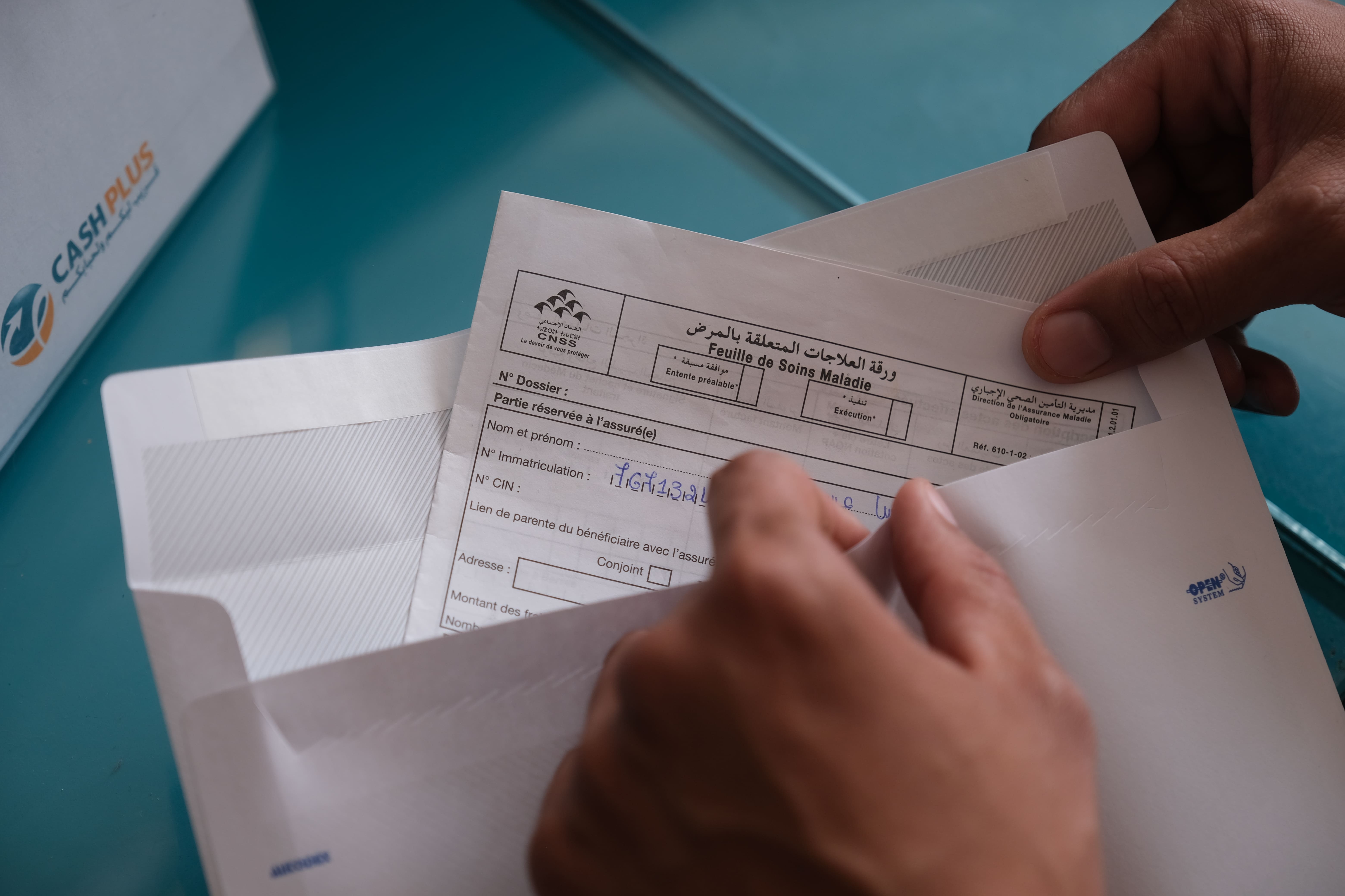 Une personne qui vient déposer son dossier CNSS dans une agence Cash Plus