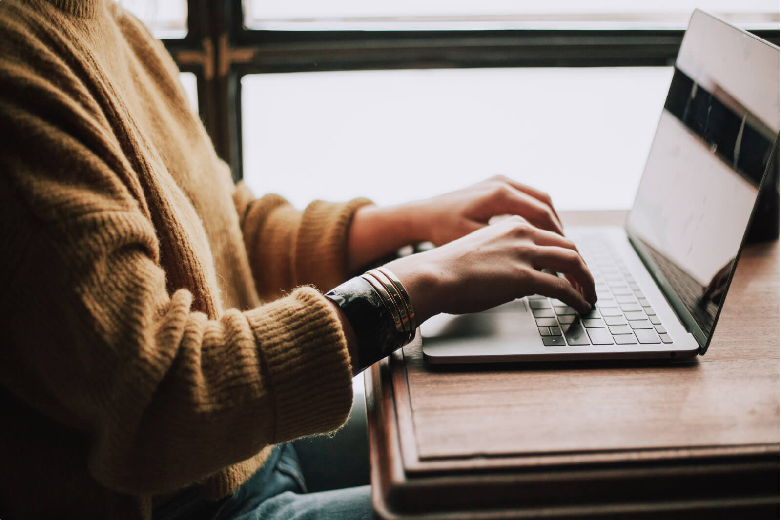 Une femme tapant sur le clavier de son ordinateur