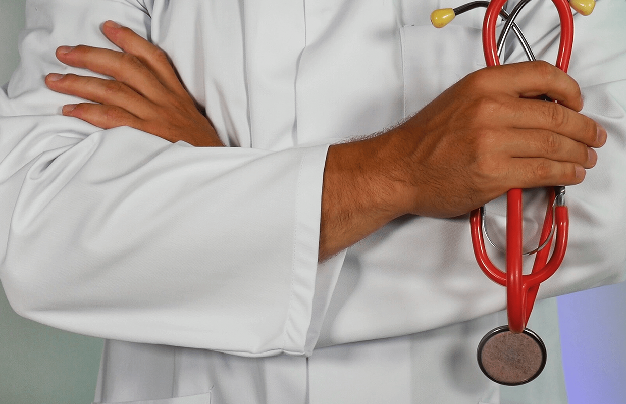 Doctor with arms crossed holding a stethoscope.