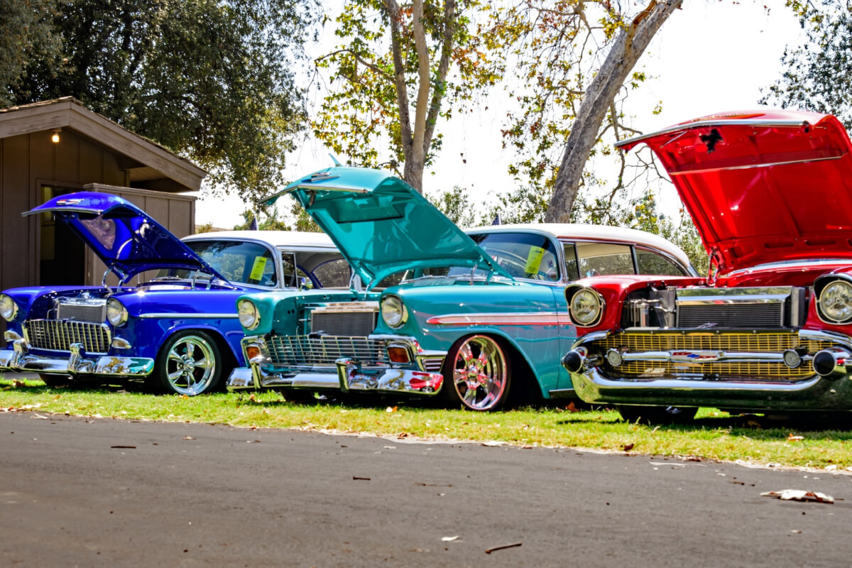 Three classic cars parked on grass