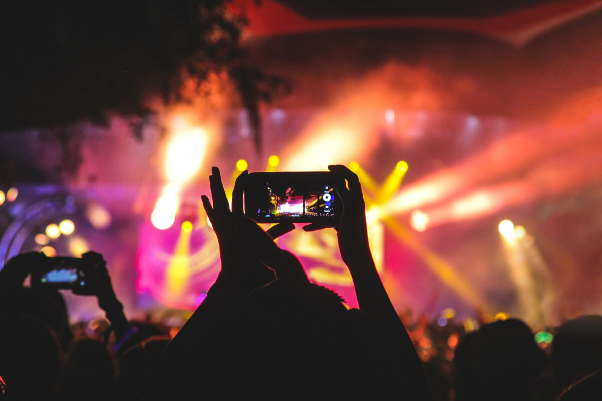 People taking picture of the stage at an event