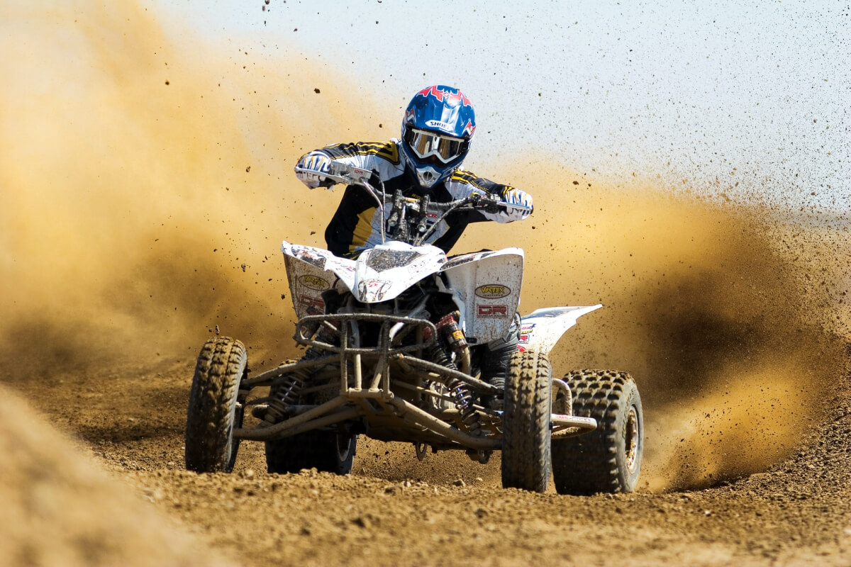 A person riding an ATV in sand
