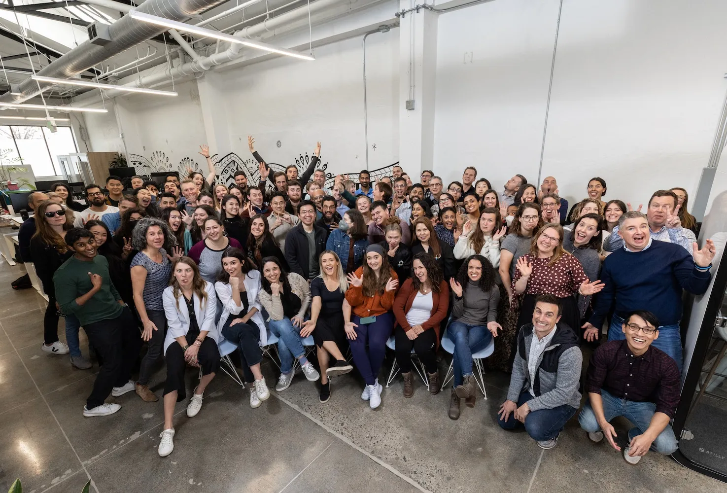 A group of people smiling and giving pose to a picture