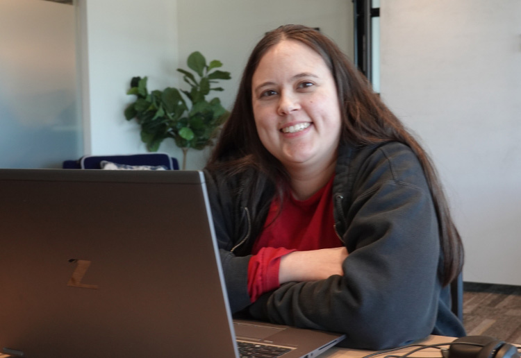 happy Seamless.AI employee smiling from behind her computer