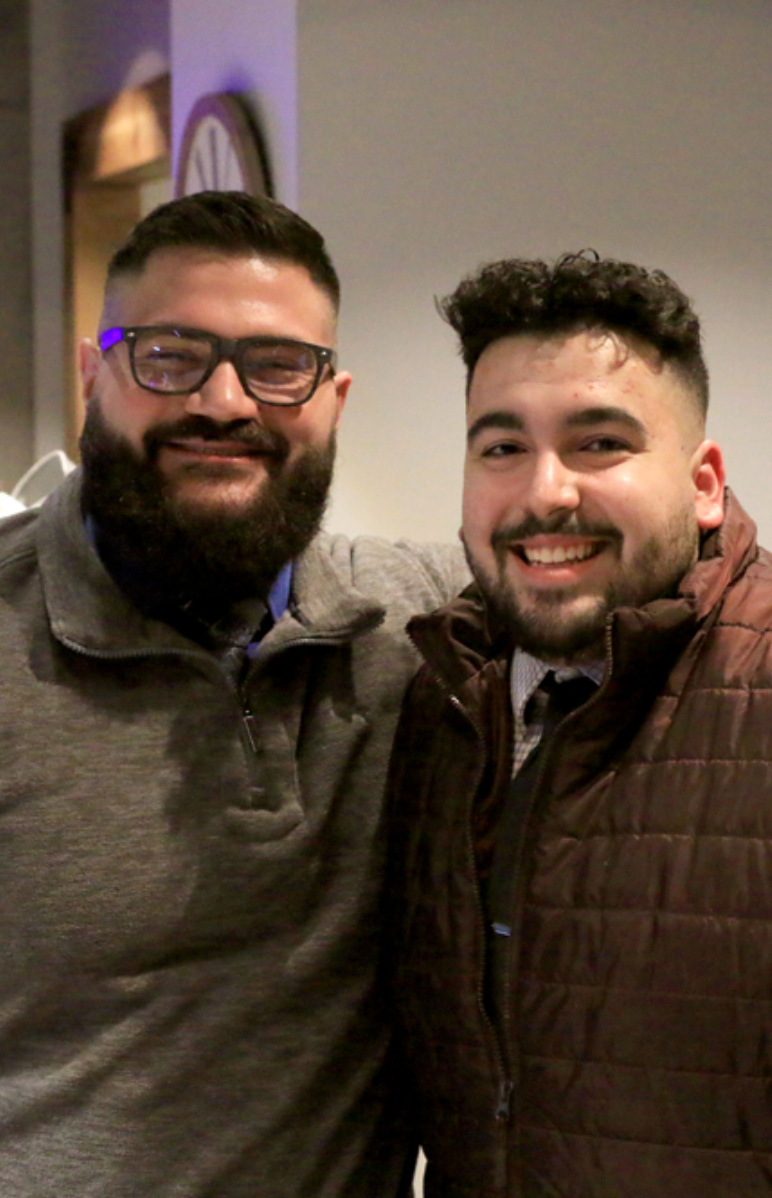 two Seamless.AI employees standing together smiling