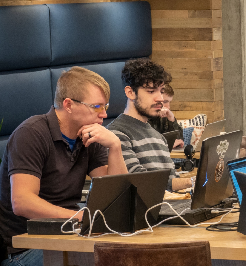 two Seamless.AI employees working on their laptops together