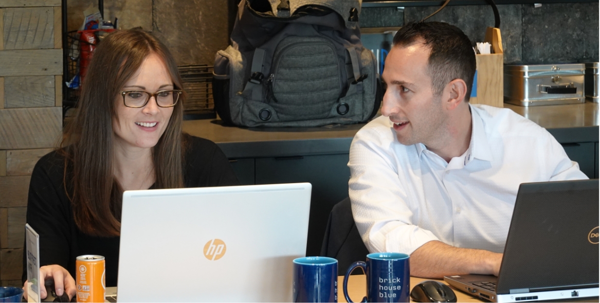 C.E.O. talking with recruiter while sitting together working on laptops