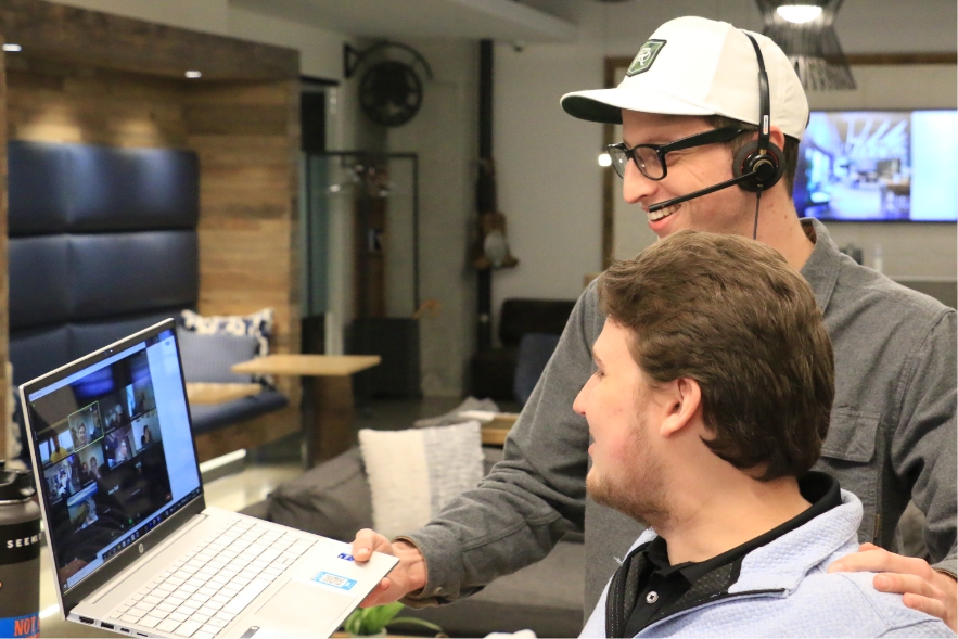 Male Seamless employee on a zoom call showing his male coworker to the group